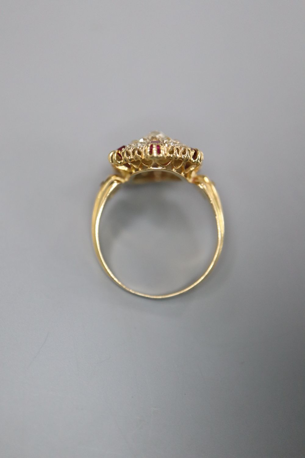 A Victorian style yellow metal ruby and diamond oval cluster ring, with central rectangular cushion cut stone, size L, gross